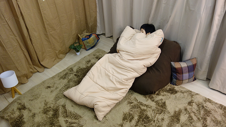 寝袋タイプの布団でごろ寝している写真