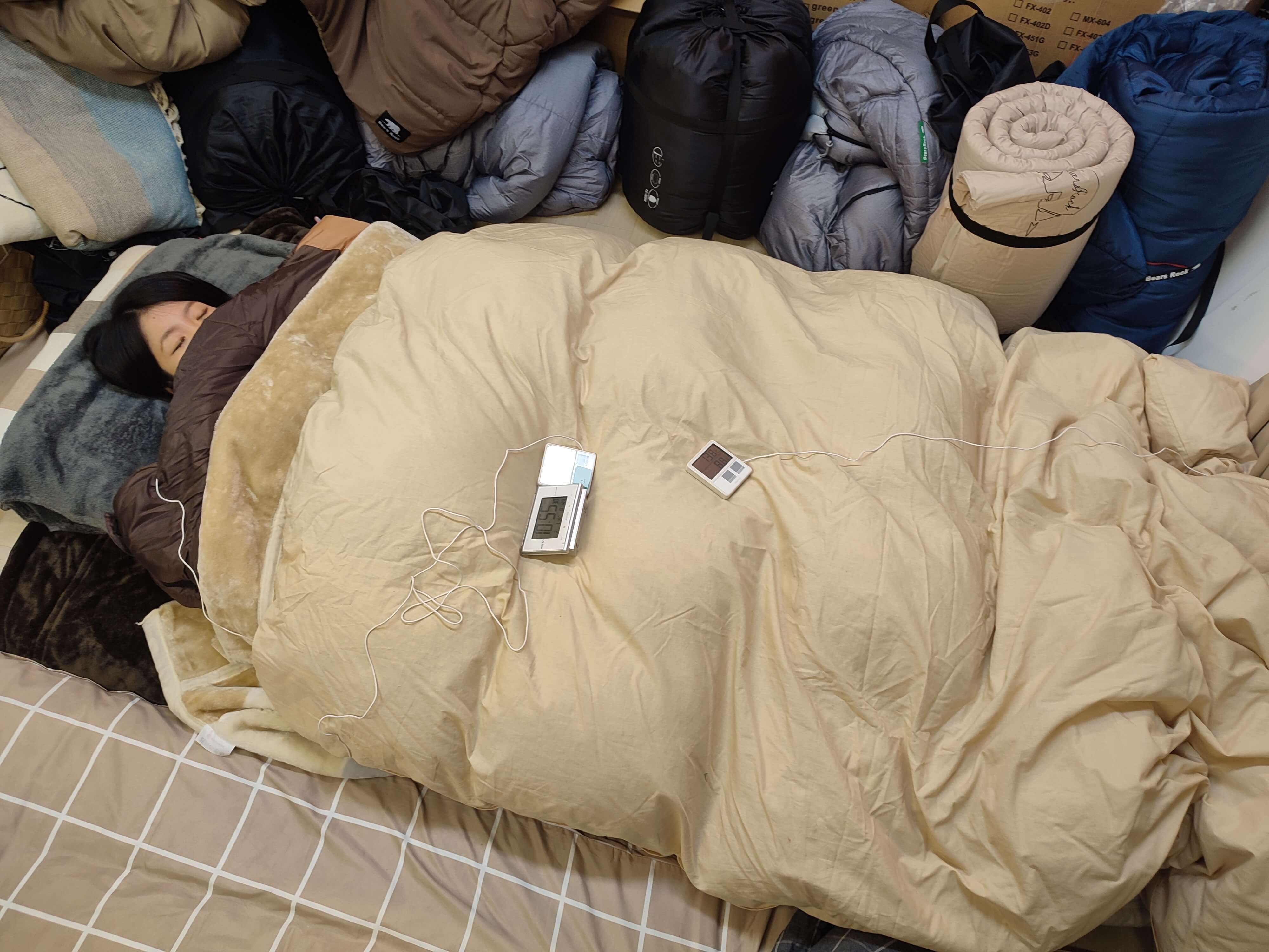布団+寝袋+毛布を使って暖かく眠る人の写真