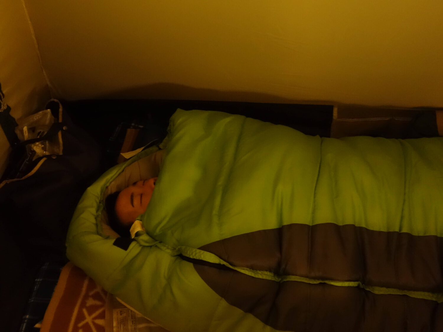 マミー型寝袋で眠っている男性
